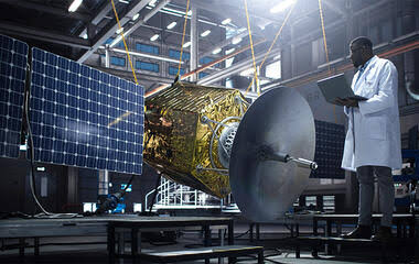An engineer examining satellite equipment